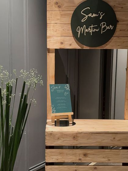 A closer look at the custom wooden martini bar. We added a small, personalized menu and a vase of baby's breath to complete the look, proving that even the smallest details matter.