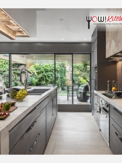 A kitchen designed for comfort and connection with nature. This galley kitchen features large windows overlooking a garden, creating a serene and inspiring cooking environment.