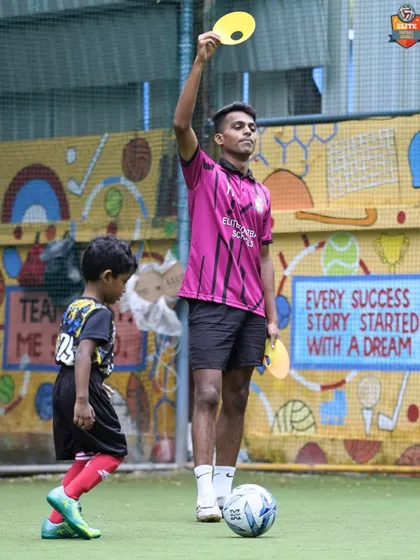 A coach uses colored discs to run a reaction drill with a young player. This is an example of the creative and effective training methods we use to make learning fun.