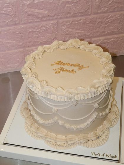 Twenty fine and absolutely iconic. This elegant off-white cake features classic vintage piping and sophisticated golden script for a truly timeless birthday celebration.