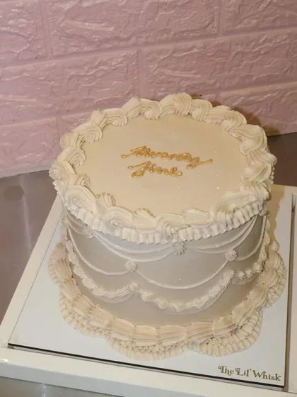 Twenty fine and absolutely iconic. This elegant off-white cake features classic vintage piping and sophisticated golden script for a truly timeless birthday celebration.