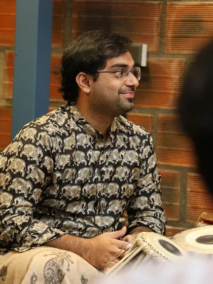 A candid shot from the 'Bhaava Sangama' concert, sharing a smile with the other artists. The camaraderie on stage is just as important as the music itself.