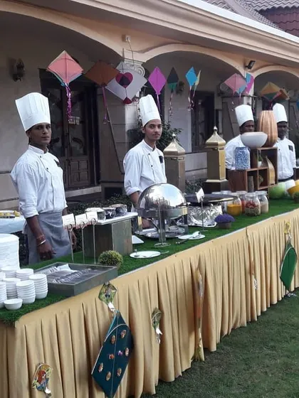 My team of chefs at an outdoor catering event, ready to serve guests from a beautifully decorated buffet line. The chef in the middle specializes in authentic Amritsari kulchas.