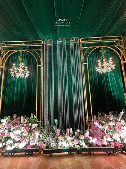 A detail of the emerald green and gold entrance, with crystal curtains, chandeliers, and lush pastel florals.