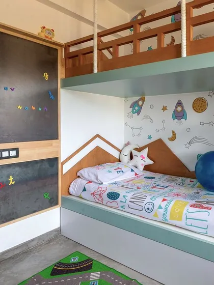 A close-up of the custom bunk bed in the T7 T8 kids' room, featuring a space-themed wallpaper and a built-in magnetic chalkboard for creative play.