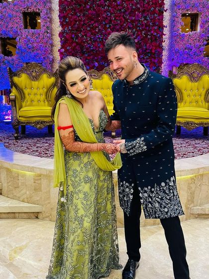 A happy, candid moment at a wedding. Our client looks stylish and comfortable in his navy blue embroidered Indo-Western jacket.