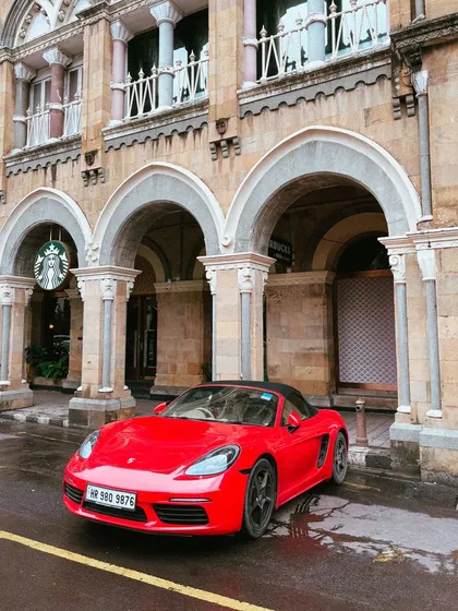 A modern classic, this red Porsche Boxster, parked in front of the historic Horniman Circle, creates a beautiful contrast between old and new.