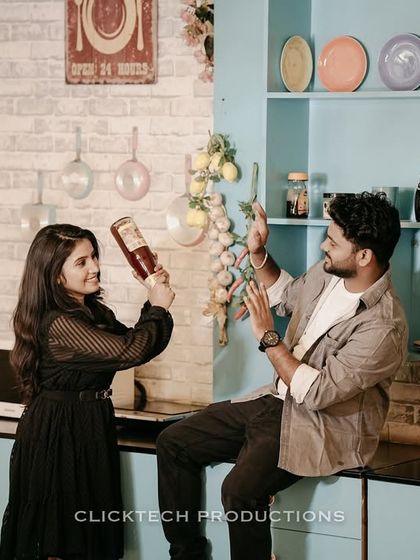 A quirky and interactive shot of a couple playing with props in a retro kitchen set.