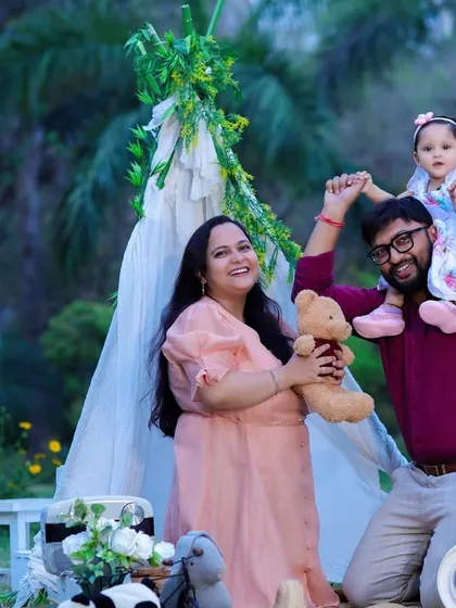 A fun and playful family moment during an outdoor first birthday shoot. The tent and props add a touch of studio magic to the natural park setting.