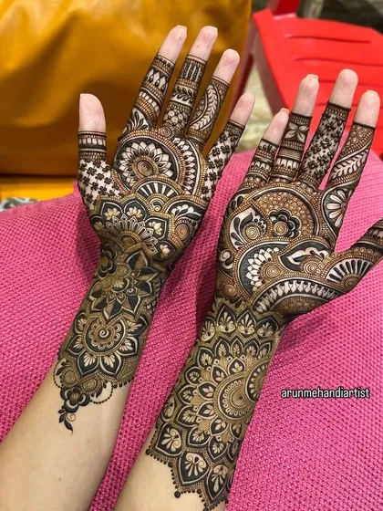 This design showcases two different but complementary patterns on each hand. One hand features a large central mandala, while the other has flowing paisley motifs, offering a unique bridal style.