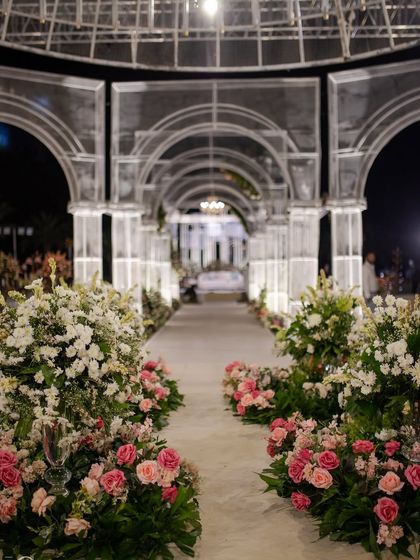 The grand aisle of the wire mesh wedding, lined with pink and white roses, leading through a series of illuminated arches. It felt like walking into a modern fairytale.