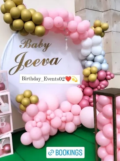 This is one of our most requested baby shower photo backdrops. It includes a full balloon ring in pink and gold, personalized with the baby's name 'Jeeva', and is paired with matching transparent 'B-A-B-Y' letter boxes.
