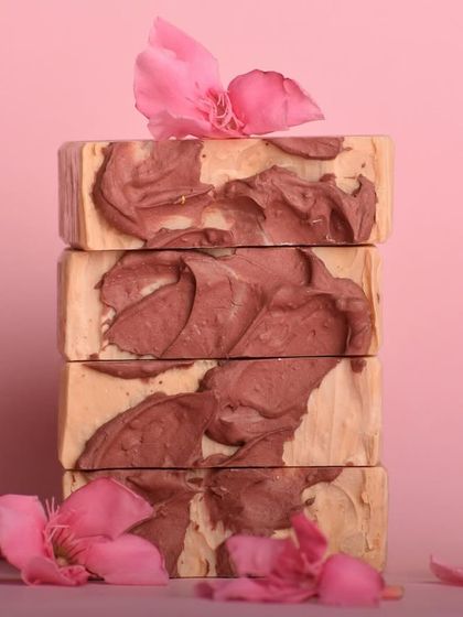 A stack of our Rose and Rosewood soaps, showing the beautiful, rustic texture on top. This soap gently exfoliates and purifies the skin, leaving it soft and fragrant.