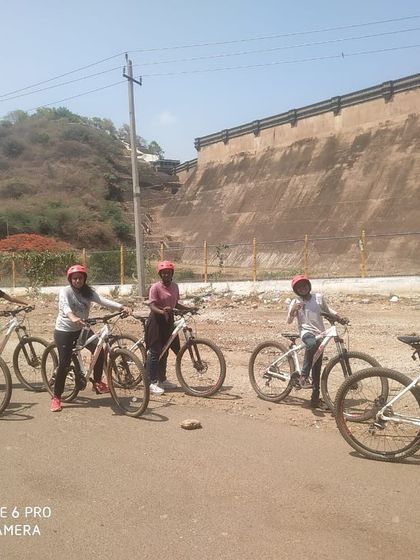 Cyclists pose with their bikes near the impressive dam wall of Vani Vilas Sagara.