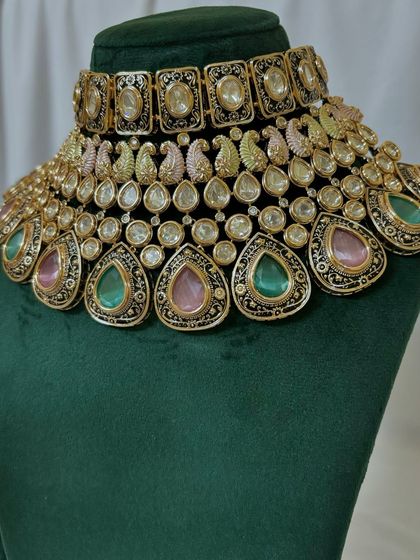 A close-up of a multi-coloured choker with pink and green Meenakari work in a paisley design. This is a unique rental piece for a colourful event.