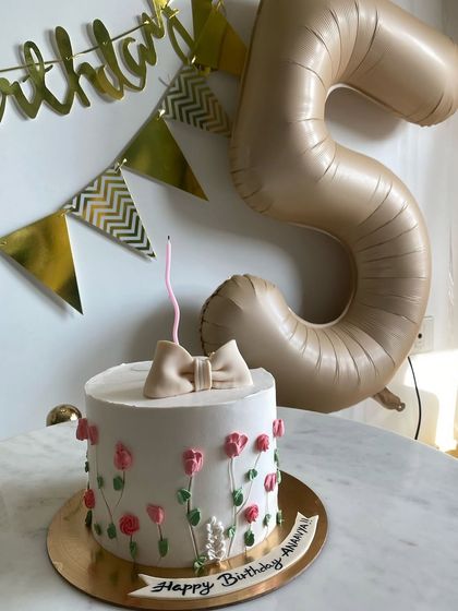 The spring-themed cake set up for the birthday celebration, looking pretty next to the party decorations.