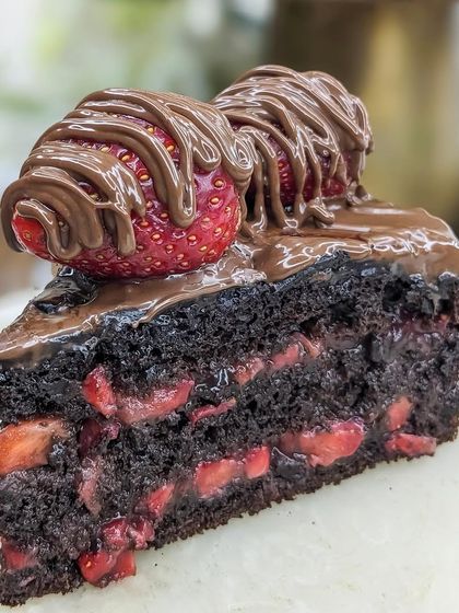 A perfect slice of our Boozy Nutella Strawberry cake. The combination of rich chocolate, fresh fruit, and premium rum makes for an unforgettable dessert experience.