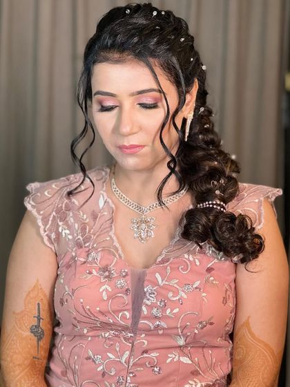 A close-up of the crystal-adorned side braid, showing the soft tendrils framing the face for a romantic touch.