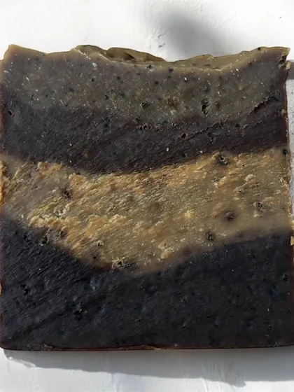 The beautiful, rustic layers of our Café Latte Soap. The different shades come from the natural ingredients like coffee and cocoa, with visible exfoliating grounds.