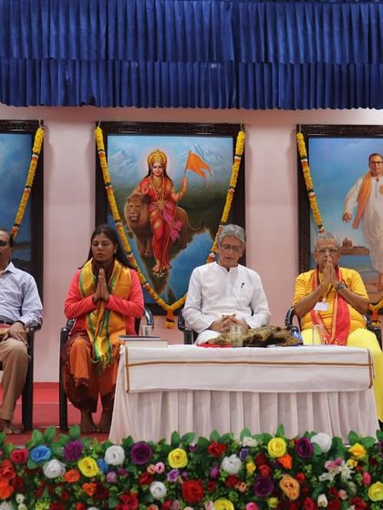 Dr. Sushama Maurya seated on stage with other revered yoga masters and dignitaries at the International Yoga Conference.