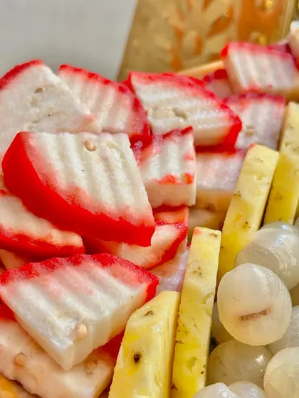 A mix of exotic fruits including red-skinned water chestnut, pineapple, and lychee. I source a wide variety of fruits to create a diverse and interesting fruit display.