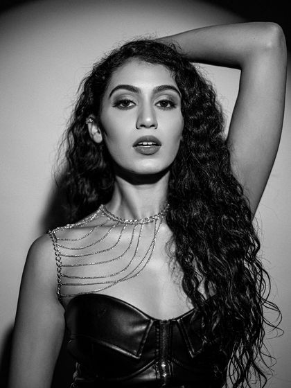 A powerful, direct-to-camera look. The makeup is bold and confident, perfect for an editorial story.