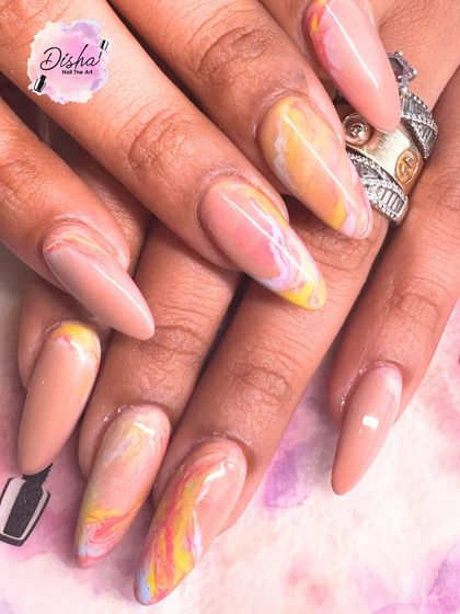 Fresh nails, fresh energy. This set features a mix of solid nude and a colorful marble effect on long, stiletto-shaped nails.