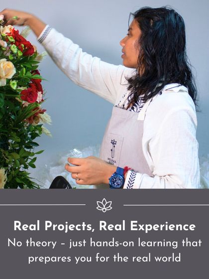 Real projects, real experience. This student is working on a tall, elegant arrangement, gaining the hands-on skills that prepare her for the real world of event floristry.