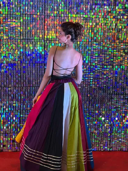 Posing against a shimmery backdrop, showing the full length of my Navratri lehenga. This outfit is a perfect example of modern festive wear for Garba and Dandiya events.