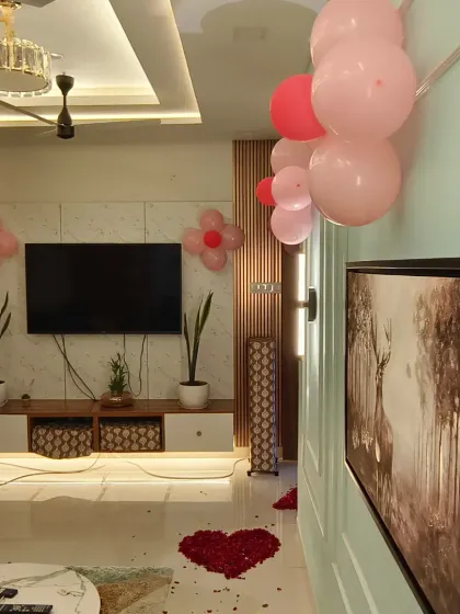 A beautiful living room decorated to welcome a baby princess home, with pink balloons and heart-shaped rose petal arrangements on the floor.