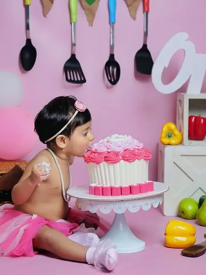 The first taste of birthday cake. This little one is just getting started on her cake smash, and her expression is one of pure delight.