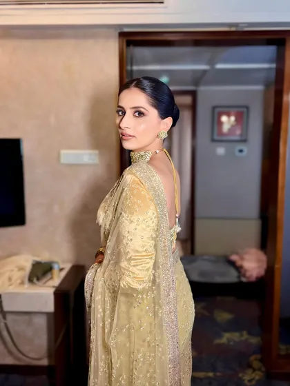 The client looking elegant with her hair styled in a simple and chic low bun. This hairstyle is perfect for letting the outfit and makeup shine.
