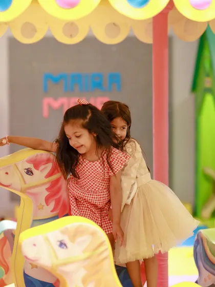 Two girls sharing a ride on the carousel, a perfect picture of friendship and fun.