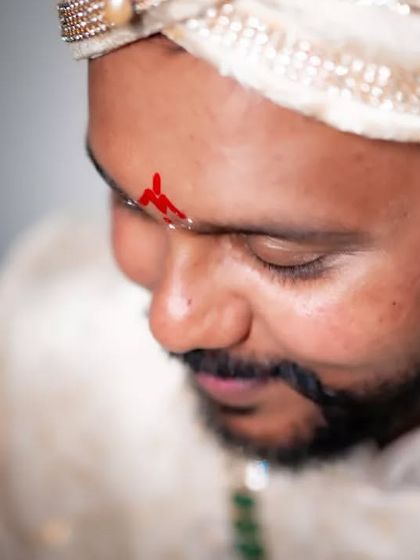 A close-up portrait of the groom, capturing the traditional tilak on his forehead and his calm expression before the ceremony.