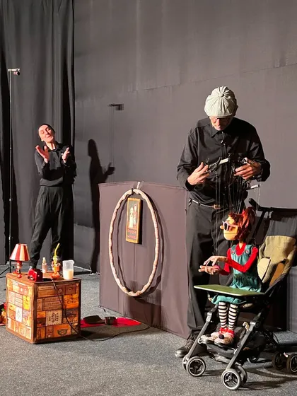A full stage view of 'Pay Attention to Those Two', showing the set and the two main marionette characters. The show is a complete theatrical experience.
