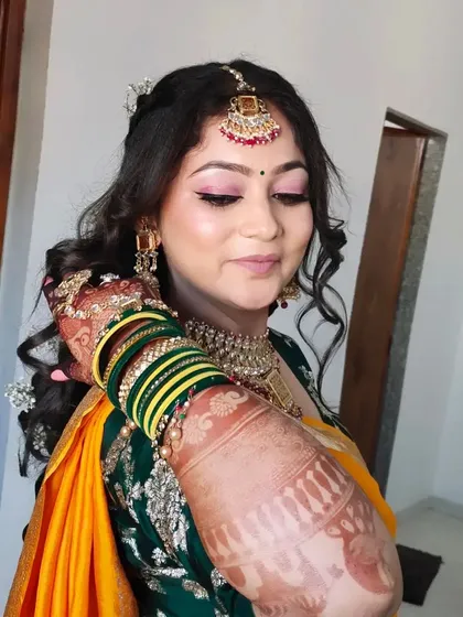 A close-up showing the detailed henna, the traditional green and yellow bangles, and the soft, radiant makeup.
