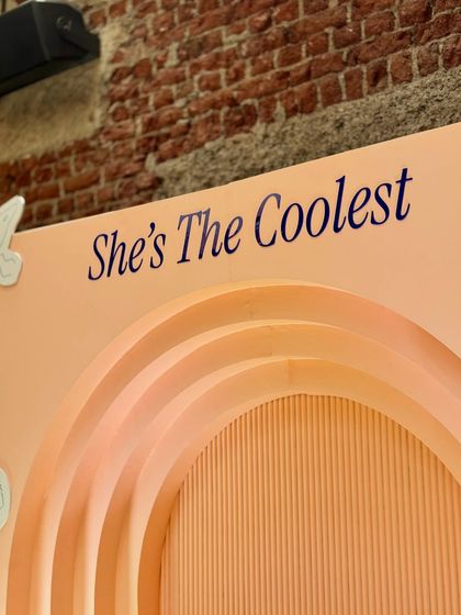 We used custom-built arched backdrops with positive affirmations like "She's The Coolest" for the Fossil event. The peach tones and ribbed textures added depth and warmth to the photo booth and display areas.