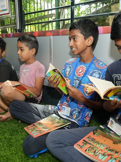 A group of boys reading books they received during a special literacy and music event on our bus.