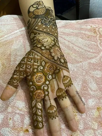 A close up of a design combining a peacock motif with floral and jhumka elements, perfect for a Teej celebration.