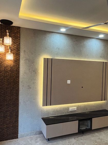 This TV unit features a backlit panel and a charcoal sheet highlighter against a texture-painted wall. The combination of different materials and lighting creates an excellent look for the living room.