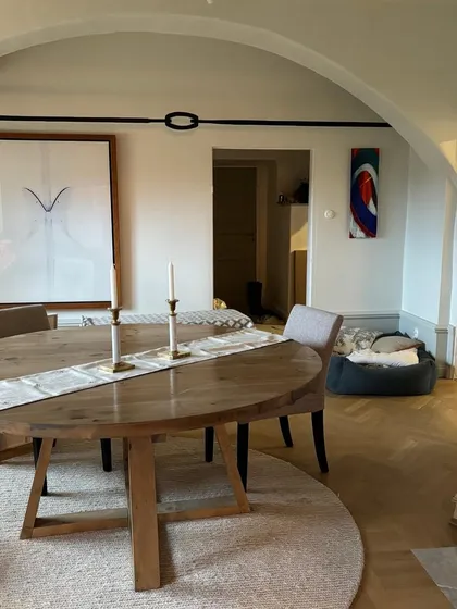 In this elegant dining space, our hand-embroidered table runner adds a touch of subtle, artisanal texture to the modern wooden table. It's a perfect example of how our textiles can complement any design style.