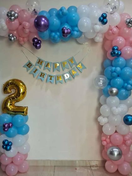 A simple balloon frame decoration for a 2nd birthday. The pink, blue, and white balloons, along with the number '2' foil balloon, create a sweet and simple party corner.