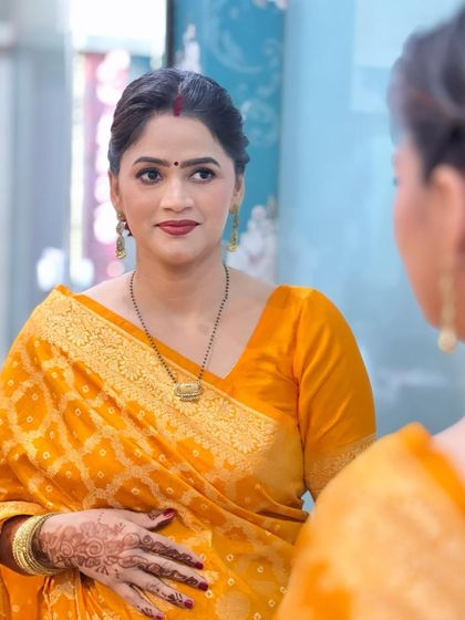 Another mirror shot, showing her looking at her reflection with a gentle smile.