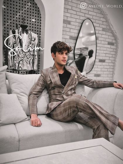 A client relaxing in a brown and beige plaid double-breasted suit. This shows my work with classic patterns and relaxed, yet sharp, tailoring.