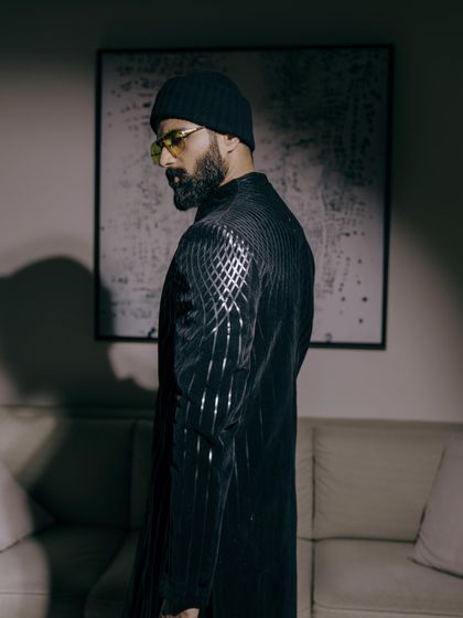 A side view of Vijay's Amit Aggarwal jacket, highlighting the unique, molded texture that is a signature of the designer. It’s wearable art.