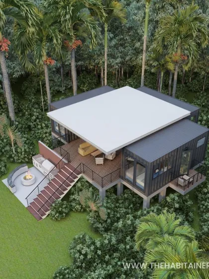 An aerial render of an upcoming 3BHK container home project. The design is elevated to create a treehouse feel and includes a large deck with a fire pit, all nestled among palm trees.