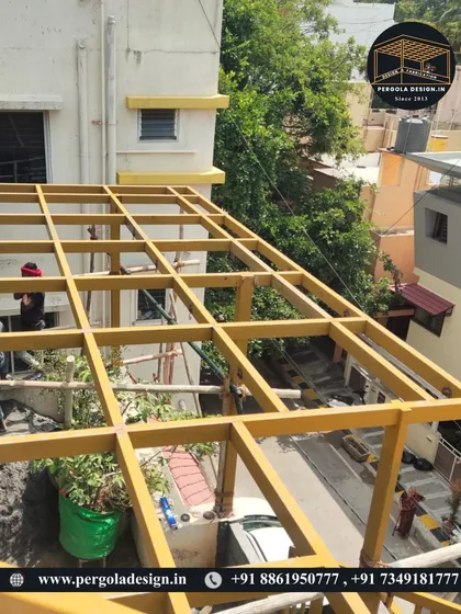 Our team is seen working on the yellow pergola frame, showcasing the hands-on approach and attention to detail during the installation phase.