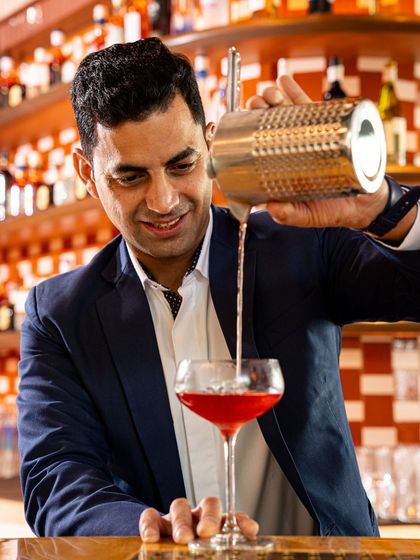 A portrait of our Head of Bars, Varun Sharma, pouring one of his signature creations. His vision and skill define the cocktail experience at Comorin.