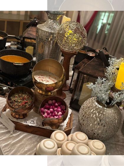 A beautifully decorated buffet table with a mix of hot dishes and condiments, all presented with style and elegance.