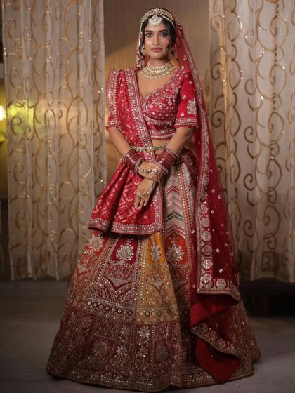 A classic red and gold bridal lehenga, rich with traditional embroidery. This is a timeless choice for the main wedding ceremony, ensuring you look and feel like a quintessential Indian bride.